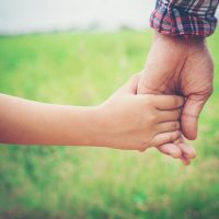 Close up of father holding his daughter hand, so sweet,family time.